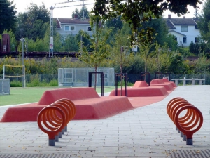 Zielony park wokół szkoły z nowoczesnymi rozwiązaniami małej architektury